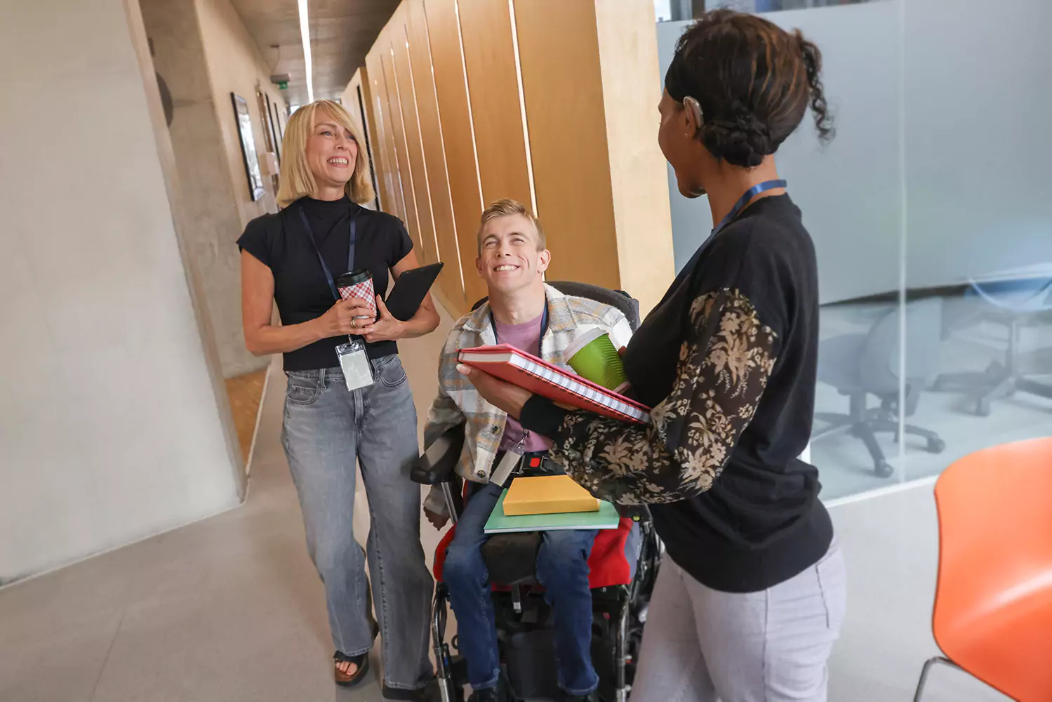Two disabled friends talking with support worker